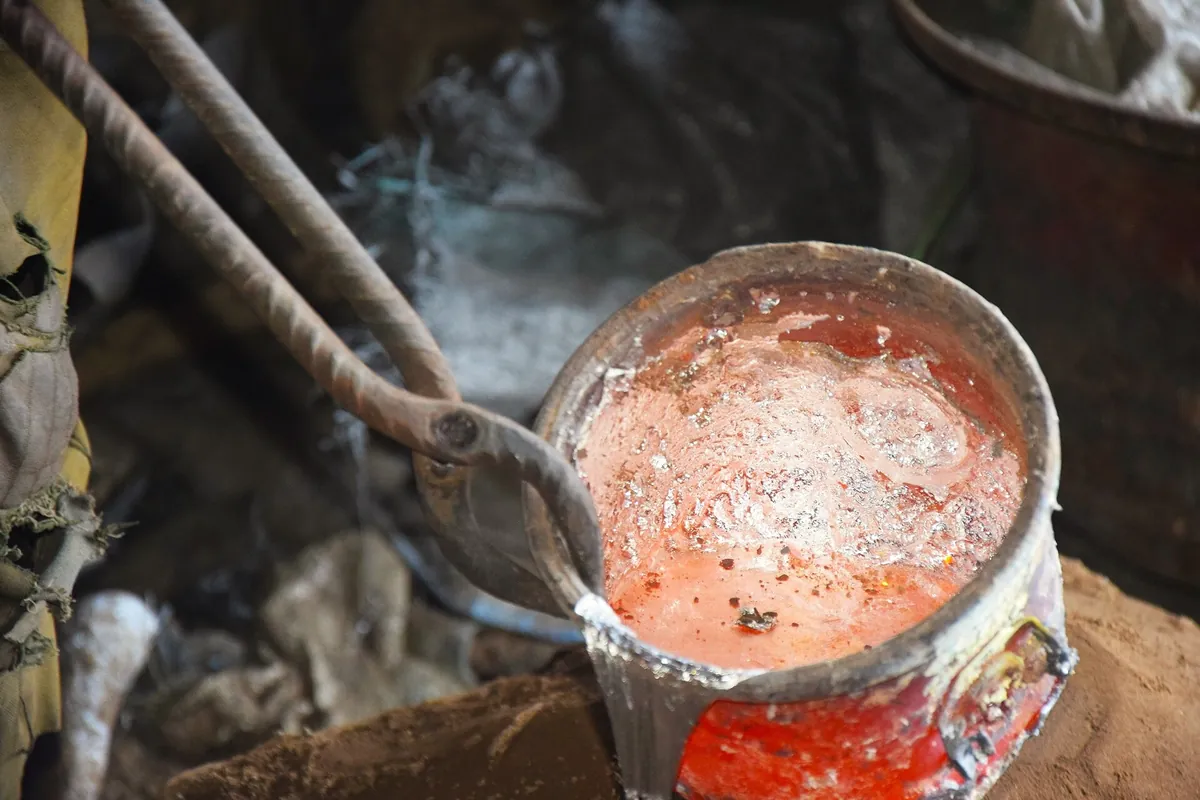 Molten aluminium being poured during sand casting